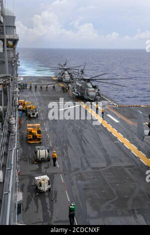 200826-N-NJ919-1080 PHILIPPINISCHES MEER (AUG 26, 2020) Schiffe, die der 31. Marine Expeditionary Unit (MEU) zugewiesen wurden, besteigen einen CH-53 Super Hengst Hubschrauber, der dem 31. MEU, Marine Medium Tiltrotor Squadron (VMM) 262 (verstärkt) auf dem Flugdeck des vorwärts eingesetzten amphibischen Sturmschiffs USS America (LHA 6) zugewiesen wurde, um einen Besuch, ein Board, such- und Beschlagnahme-Übung. America, Flaggschiff der America Amphibious Ready Group, die zusammen mit der 31. Marine Expeditionary Unit dem Amphibious Squadron Eleven zugewiesen wurde, ist im 7. Flottenbereich der USA tätig, um die Interoperabilität zu verbessern Stockfoto