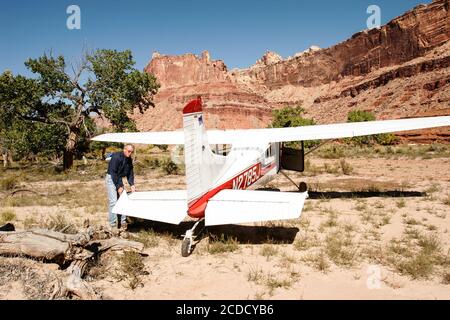 Der Pilot überprüft seine Cessna 185 Skywagon der Utah Backcountry Pilots Association nach der Landung auf der abgelegenen mexikanischen Bergflugplatz auf der Stockfoto