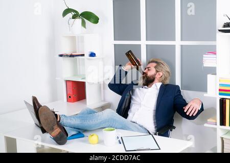 Müde gelangweilte Geschäftsmann Gähnen am Arbeitsplatz in der Nähe von Laptop, langweilige Arbeit, Sackgasse Job, Überarbeit extra nach Stunden, Alkohol trinken. Stockfoto