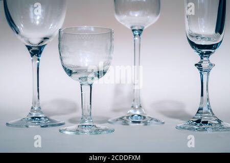 Weingläser auf einem sonnigen Tisch werfen Schatten, Sonnenlicht, Kristallglas, Weingläser, Sektflöte. Stockfoto