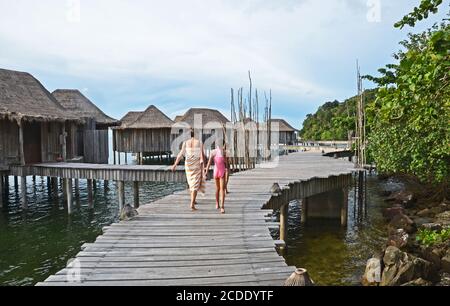 Gäste gehen auf der Promenade, die Zugang zu den Überwasser-Villen im Song Saa privaten Inselresort, Kambodscha gibt Stockfoto