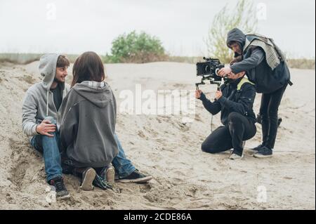 Hinter den Kulissen. Schauspieler und Schauspielerin vor der Kamera auf dem Film set Outdoor-Location. Gruppe-Filmszene Stockfoto