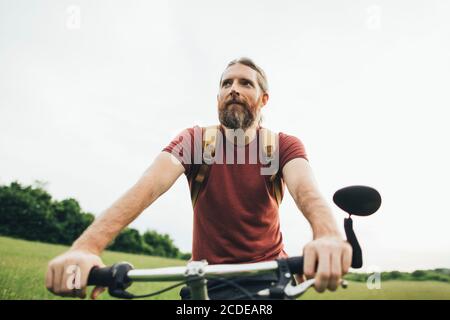 Bärtiger Mann auf dem Fahrrad in der Natur Stockfoto