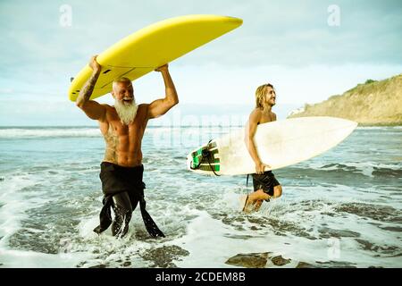 Beste Freunde tun Surfen im Sommer . Menschen, die in den Ozean gehen. Sportlicher People Lifestyle und Extremsportkonzept - Bild Stockfoto