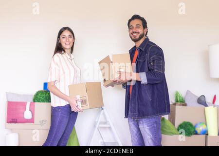 Glückliches junges Paar Umzug in neue Eigenschaft Haus. Arbeiter mit glücklichen Gefühlen halten Kisten im neuen Büro. Mieten, kaufen Wohnung und Lifestyle concep Stockfoto