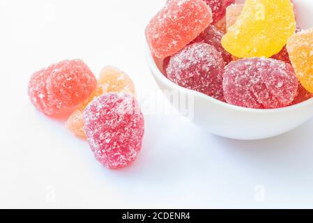 Gelee Bonbons in weißer Schale auf weißem Hintergrund und In der Nähe der Schüssel Stockfoto