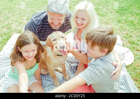 Glückliche Familie macht ein Selfie, für den Hund ist nicht sehr wichtig. Eltern und Kinder haben Spaß im Urlaub. Reisen, Urlaub und Liebeskonzept. F Stockfoto