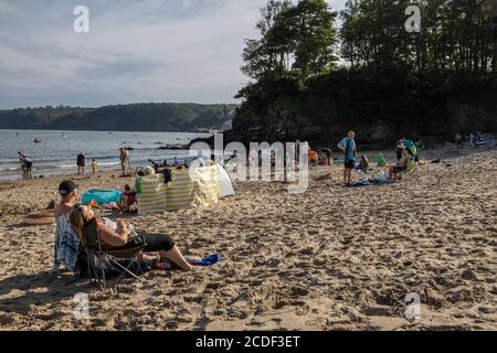 Menschen, die das warme Wetter am Coppet Hall Beach, Saundersfoot Bay, Pembrokeshire, West Wales, Großbritannien genießen Stockfoto