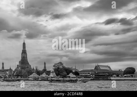 Schöner Blick auf den berühmten buddhistischen Tempel der Morgenröte, Wat Arun, am Chao Phraya Fluss, gegen einen dramatischen Himmel, Bangkok, Thailand Stockfoto