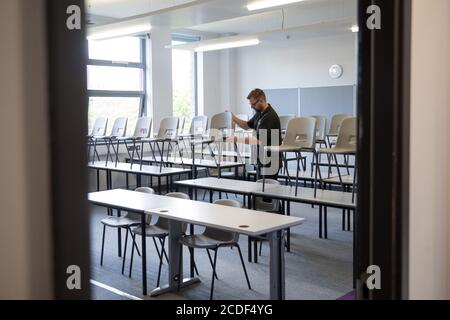 Die Lehrstühle werden in einem Klassenzimmer der Ark Charter Academy in Portsmouth abgesetzt, da die Vorbereitungen vor Beginn des neuen Semesters getroffen werden. Stockfoto