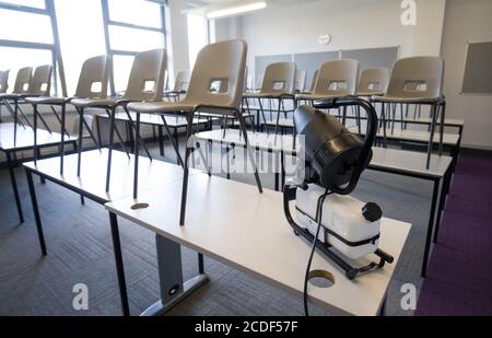 Eine Nebelmaschine, die ein ganzes Klassenzimmer desinfizieren kann, wird in einem Klassenzimmer der Ark Charter Academy in Portsmouth aufgestellt, da die Vorbereitungen vor Beginn des neuen Semesters getroffen werden. Stockfoto