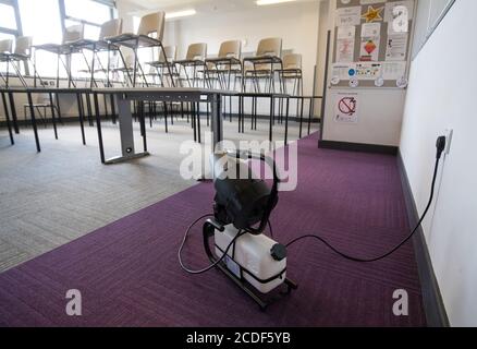 Eine Nebelmaschine, die ein ganzes Klassenzimmer desinfizieren kann, wird in einem Klassenzimmer der Ark Charter Academy in Portsmouth aufgestellt, da die Vorbereitungen vor Beginn des neuen Semesters getroffen werden. Stockfoto