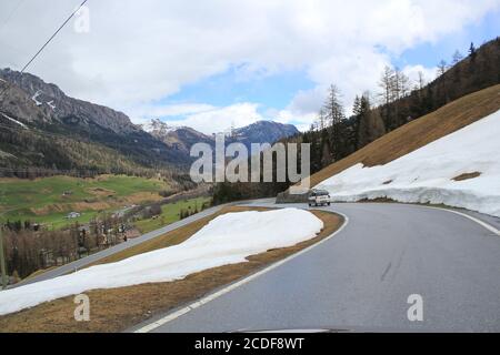 Straße durch die Berge mit schmelzendem Schnee im Frühling Stockfoto