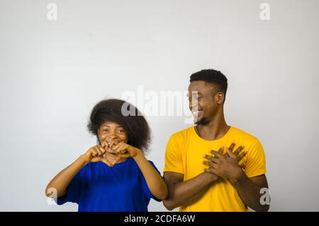 Cute junge afrikanische Paar lächelnd und zeigt Liebe Gesten mit Hände Stockfoto