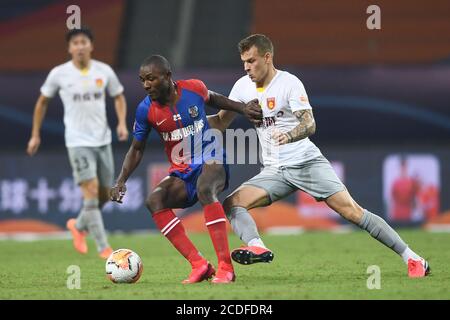 Kamerunischer Profifußballspieler Joseph Minala von Qingdao Huanghai F.C., links, schützt den Ball vor argentinischem Fußballspieler Ezequiel Lavezzi von Hebei China Fortune F.C., rechts, während des siebte Runde Spiels der 2020 Chinese Super League (CSL), Stadt Suzhou, ostchinesische Provinz Jiangsu, 27. August 2020. Qingdao Huanghai F.C. wurde von Hebei China Fortune F.C. mit 1:2 besiegt. Stockfoto