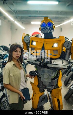 Roboter Transformator steht in der Garage in der Nähe Mädchen. Stockfoto