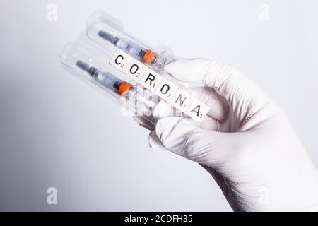 Bamberg, Deutschland. August 2020. Bamberg, 28. August 2020: Symbole - Coronavirus - 08/28/2020 EINE Hand in Gummihandschuhen, Impfstoff mit Spritze und Corona Quelle: dpa/Alamy Live News Stockfoto