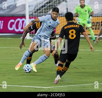 Kansas City, Kansas, USA. August 2020. Sportlicher KC-Stürmer Alan Pulido #9 (Mitte) im Offensive gegen Houston Dynamo Mittelfeldspieler Memo Rodriguez #8 (vorne) und Houston Dynamo Verteidiger Maynor Figueroa #15 (hinten) während der ersten Hälfte des Spiels. Kredit: Serena S.Y. Hsu/ZUMA Wire/Alamy Live News Stockfoto