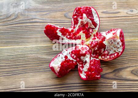 Öffnen Sie frischen reifen Granatapfel auf braunem Holzhintergrund. Reifer Granat. Selektiver Fokus Stockfoto