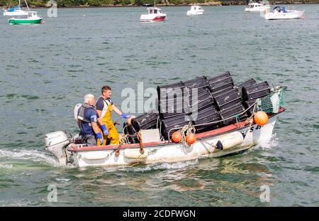 Garnelenfischer, die mit einem Boot voller Garnelentöpfe fahren. Stockfoto