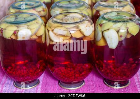 Hausgemachtes Fruchtkompott aus der Dose für den Winter. Kompott aus Äpfeln und roter Johannisbeere. Invertierte Gläser Stockfoto