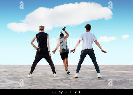 Drei unerkennbare junge Männer tanzen Sporttänze, Hip-Hop oder Break-Dance im Freien. Teenage Lifestyle und urbane Jugendkultur Konzept. Straßentanz. Stockfoto