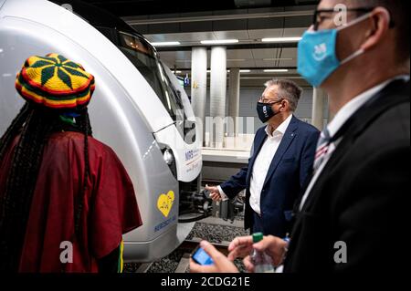 28. August 2020, Brandenburg, Schönefeld: Michael Halberstadt (2. V.r.), Geschäftsführer Personal des Flughafens Berlin-Brandenburg, begrüßt den besonderen Kulturzug von Chemnitz zum Flughafen BER der Hauptstadt. Die Initiative Herzschlag - das Chemnitzer Bürgerfest will auf Chemnitzer Bewerbung für die Kulturhauptstadt aufmerksam machen. Foto: Fabian Sommer/dpa Stockfoto
