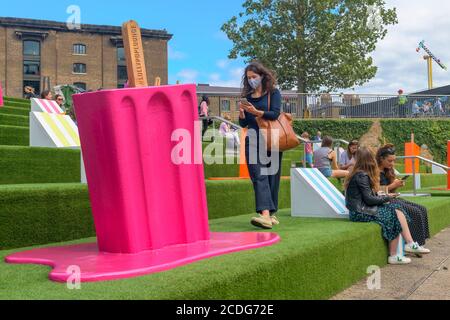 Auf dem Regent's Canal in der Nähe von King's Cross in London wurden clevere Wege zur Gewährleistung einer „sozialen Distanzierung“ gesetzt. Eine Dame, die einen Gesichtsbedeckungswal trägt Stockfoto