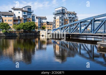 Moderne Wohnblocks auf Rennie’s Isle und Victoria Swing Bridge spiegeln sich im Wasser von Leith in Leith, Edinburgh, Schottland, Großbritannien Stockfoto