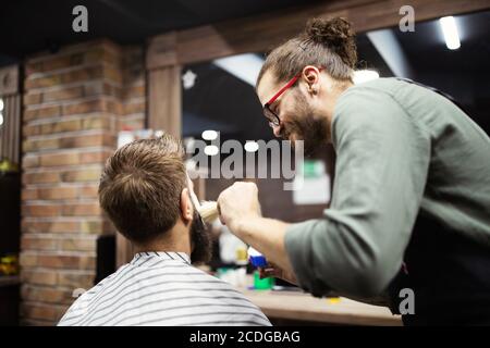 Kunden bei Bart rasieren im Friseurladen Stockfoto