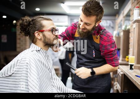 Kunden bei Bart rasieren im Friseurladen Stockfoto