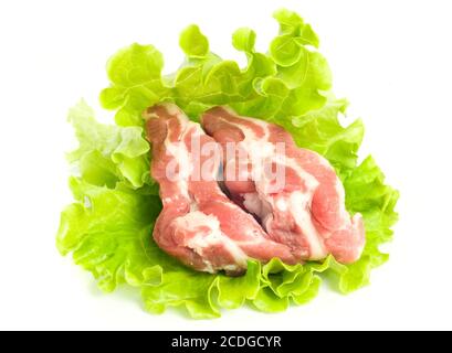 Fleischstücke aus Schweinefleisch auf grünem Salat Stockfoto