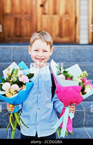 Blumenstrauß für den ersten geliebten Lehrer am ersten September. Blumen für die letzte Glocke. Tag des Wissens. Beginn des Schuljahres. Erstklässler mit Blumenstrauß in Stockfoto