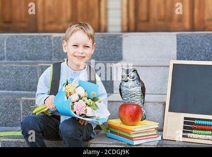 Blumenstrauß für den ersten geliebten Lehrer am ersten September. Blumen für die letzte Glocke. Tag des Wissens. Beginn des Schuljahres. Erstklässler mit Blumenstrauß in Stockfoto