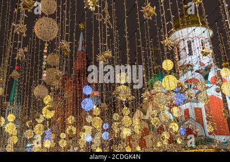 Silvesterbeleuchtung in der Nikolskaja-Straße, mit (links nach rechts) Nikolskaja-Turm, Staatliches Historisches Museum und Kasaner Kathedrale im Hintergrund, MOSC Stockfoto