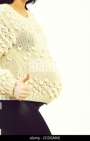 Weibliche Hände der schwangeren Frau, cool in beiger Strickpullover auf weißem studio Hintergrund isoliert Stockfoto