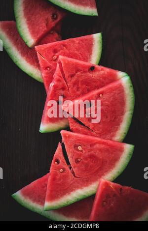 Reifen Wassermelonen Scheiben auf einem dunklen Hintergrund von oben aufgenommen. Sommer Essen Flatlay Stockfoto