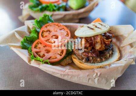 Großer appetitlich hawaiianischer Burger mit Speck, Zwiebel auf einem Rinderpastete Stockfoto