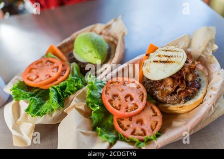 Großer appetitlich hawaiianischer Burger mit Speck, Zwiebel auf einem Rinderpastete Stockfoto