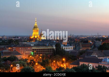 Skyline bei Sonnenuntergang aus einem hohen Blickwinkel von Timisoara, Rumänien mit Fokus auf das wichtigste Wahrzeichen der Stadt, die orthodoxe Kathedrale. Stockfoto