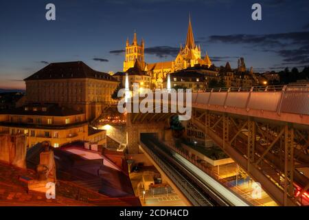 Notre-Dame de Lausanne ist eine Kathedrale aus dem 12. Jahrhundert, die über der Stadt Lausanne in der Westschweiz thront. Szene mit dem Hintergrund eines Sonnenuntergangs aus Stockfoto