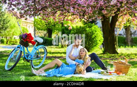 Für immer Liebe. Jubiläum feiern. Glückliche Familie im Sommerpark. Essen und Trinken. Mann und Frau. Romantisches Paar auf Picknick. Liebe Datum im Frühjahr. Entspannen Sie sich unter blühenden Sakura. Paar in der Liebe. Stockfoto