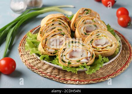 Pita-Rolle mit Hering, Kartoffeln und Zwiebeln auf hellblauem Hintergrund, horizontales Format Stockfoto