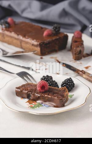 Hausgemachter Zimtkuchen mit Marmelade und dunkler Schokolade auf dem Teller serviert, Nahaufnahme. Serviert und fertig zum Essen. Leckerer Kuchen, leckerer Kuchen. Stockfoto