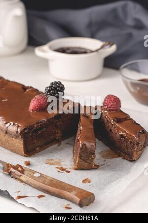 Hausgemachter Zimtkuchen mit Marmelade und dunkler Schokolade, in Stücke geschnitten, Nahaufnahme. Leckerer Kuchen, leckerer Kuchen. Stockfoto