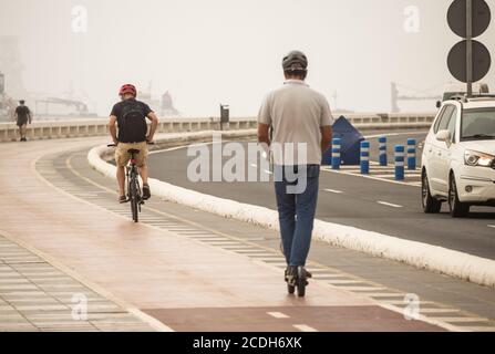 Radfahrer und Elektroroller auf Radweg vom Verkehr getrennt. Spanien Stockfoto