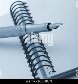 Füllfederhalter auf einem gelben notebook Stockfoto