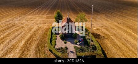 Kapelle mit altem Mann in der Mitte eines Getreides Ein Stockfoto