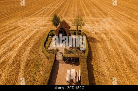 Kapelle mit altem Mann in der Mitte eines Getreides Ein Stockfoto