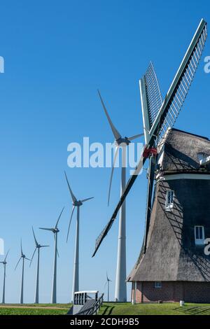 Alte Windmühle in Kombination mit neuen Windturbinen, die saubere Energie erzeugen Stockfoto